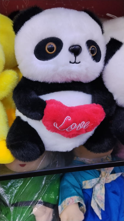 Panda plush toy with heart held in hand for size reference